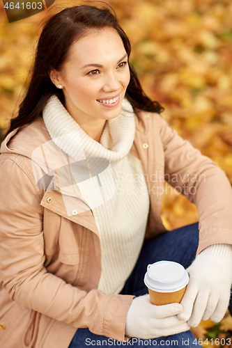 Image of woman drinking takeaway coffee in autumn park