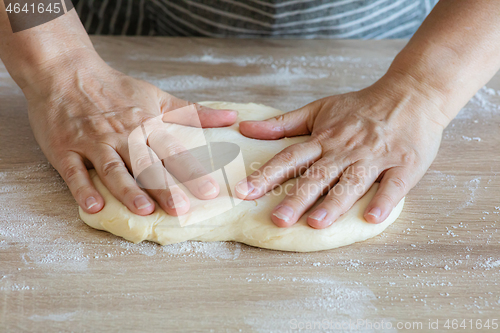 Image of yeast dough and human arms