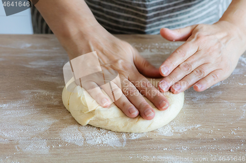 Image of yeast dough and human arms