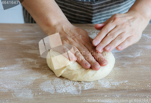 Image of yeast dough and human arms