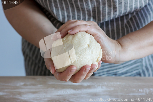 Image of yeast dough and human arms