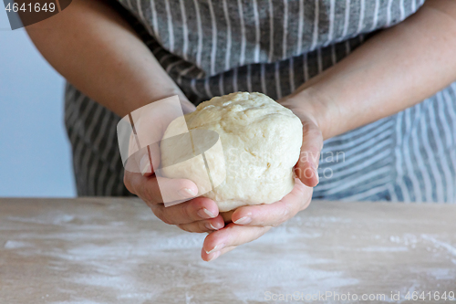 Image of yeast dough and human arms