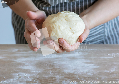 Image of yeast dough and human arms