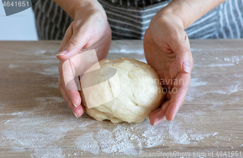 Image of yeast dough and human arms