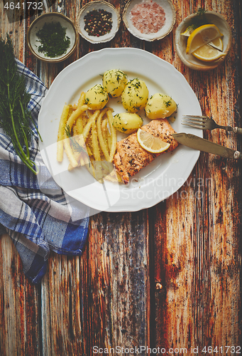 Image of Fresh and tasty baked salmon served with young boiled potatoes and yellow bean.