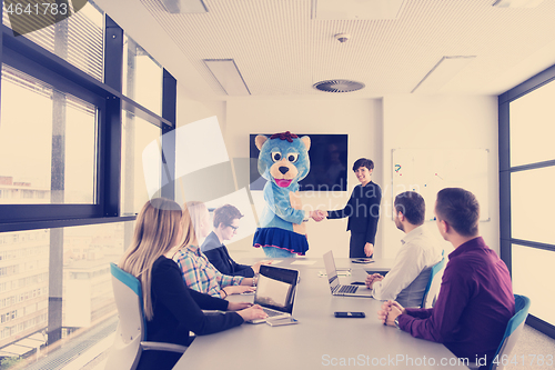 Image of boss dresed as bear having fun with business people in trendy of