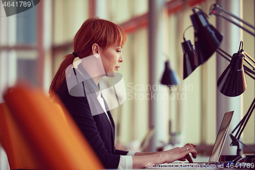 Image of business woman working on computer at office