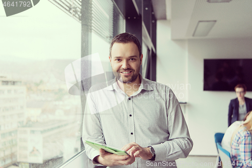 Image of Businessman Using Tablet In Office Building by window