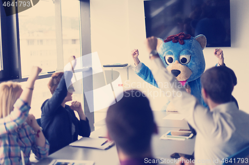 Image of boss dresed as bear having fun with business people in trendy of