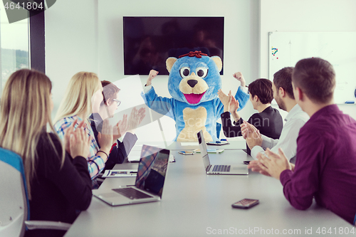 Image of boss dresed as bear having fun with business people in trendy of