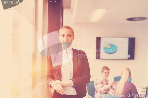 Image of portrait of young business woman at office with team on meeting 
