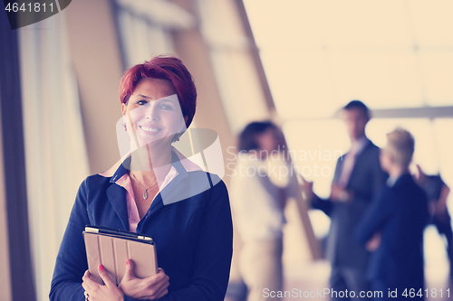 Image of business woman  at office with tablet  in front  as team leader