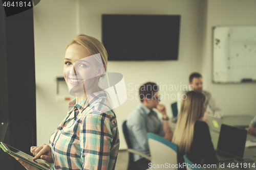 Image of Pretty Businesswoman Using Tablet In Office Building by window