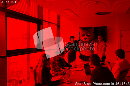 Image of boss dresed as bear having fun with business people in trendy of