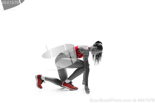 Image of Portrait of young sporty woman at starting block of race isolated over white background