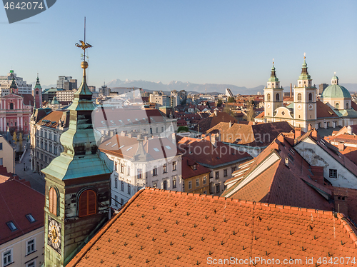 Image of Scenic panoramic aerial drone view of rooftops of medieval city center, town hall and cathedral church in Ljubljana, capital of Slovenia, at sunset