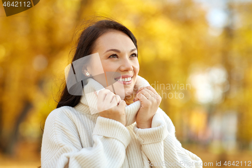 Image of portrait of happy young woman in autumn park