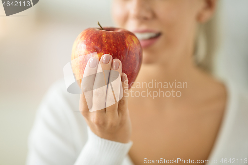 Image of close up of woman holding ripe red apple