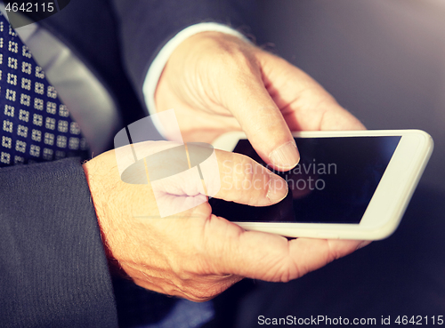 Image of senior businessman texting on smartphone