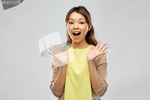 Image of happy asian woman over grey background