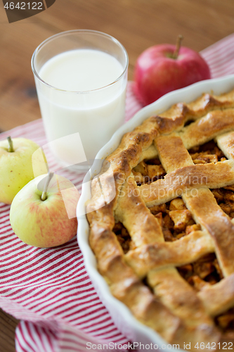 Image of apple pie in baking mold on wooden table