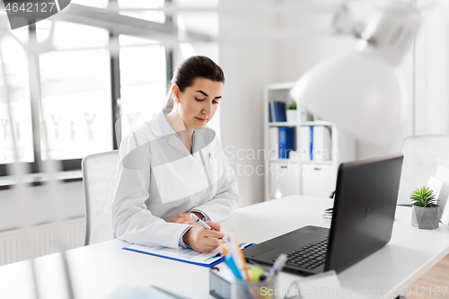 Image of doctor with laptop and medical report at hospital