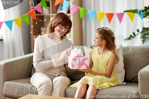 Image of grandmother giving granddaughter birthday gift