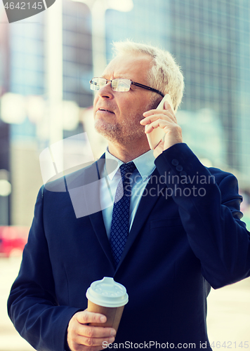 Image of senior businessman calling on smartphone in city