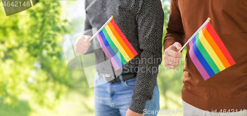 Image of close up of male couple with gay pride flags