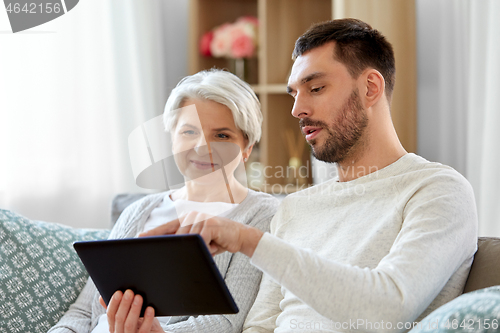 Image of old mother and adult son with tablet pc at home