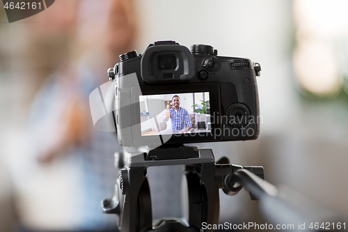 Image of camera recording video blogger showing thumbs up