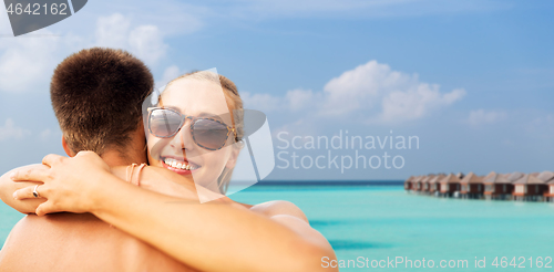 Image of happy couple hugging on summer beach