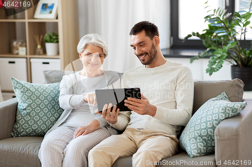 Image of old mother and adult son with tablet pc at home