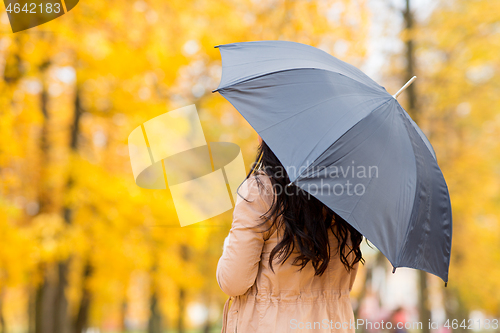 Image of young woman with umbrella in autumn park