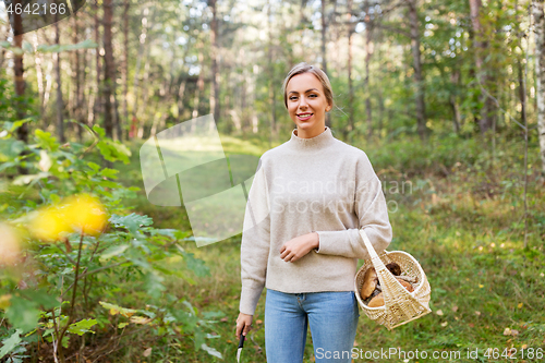 Image of woman with basket picking mushrooms in forest