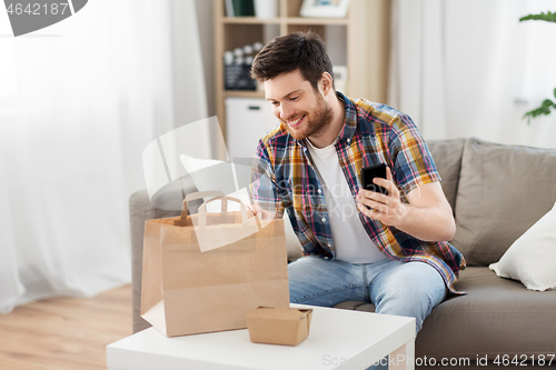 Image of man checking takeaway food order at home