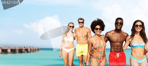 Image of happy friends hugging on summer beach