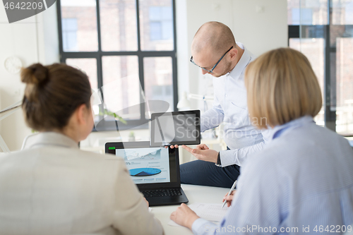 Image of close up of business team with tablet pc at office