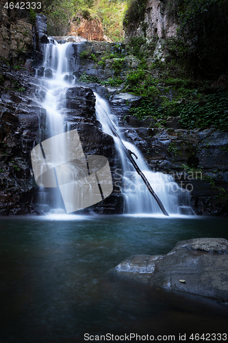 Image of Waterfall tumbling over a ledge into a beautiful swimming hole b