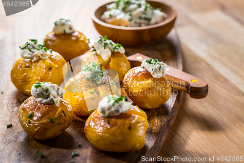 Image of Oven baked potatoes with sour cream with butter and chives