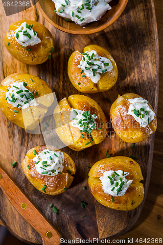 Image of Oven baked potatoes with sour cream with butter and chives