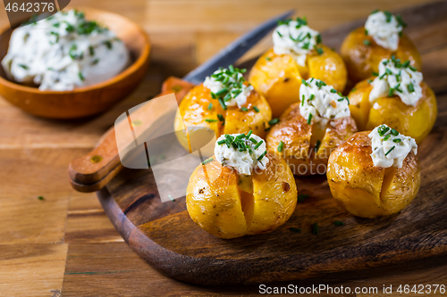 Image of Oven baked potatoes with sour cream with butter and chives