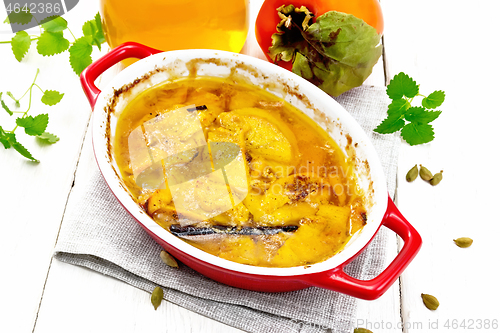 Image of Persimmons baked with honey in pan on light board