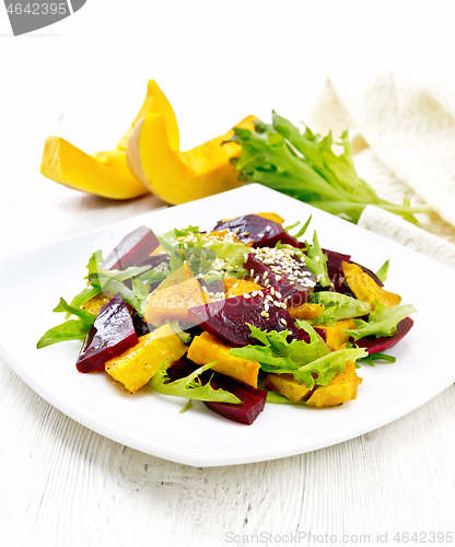 Image of Salad of pumpkin and beetroot in plate on light wooden board