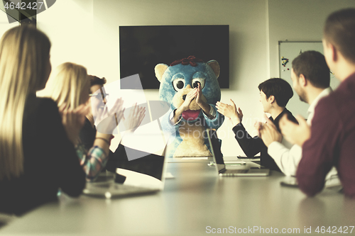 Image of boss dresed as bear having fun with business people in trendy of