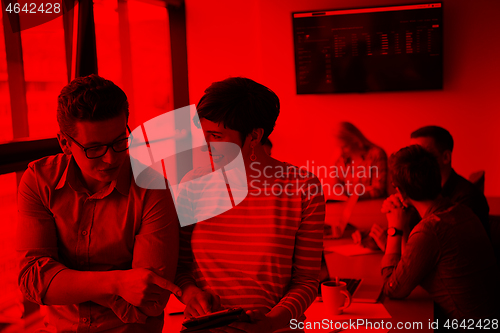 Image of Two Business People Working With Tablet in office