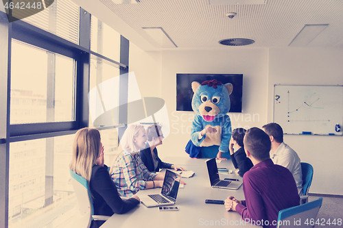 Image of boss dresed as bear having fun with business people in trendy of