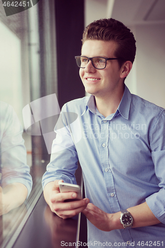 Image of Businessman Standing In A Modern Building Near The Window With P