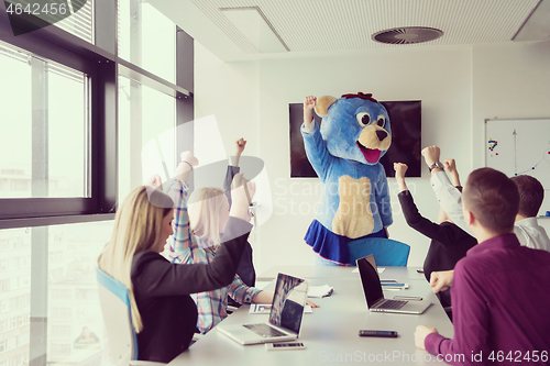 Image of boss dresed as bear having fun with business people in trendy of