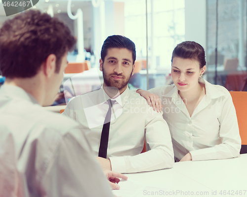 Image of young couple signing contract documents on partners back